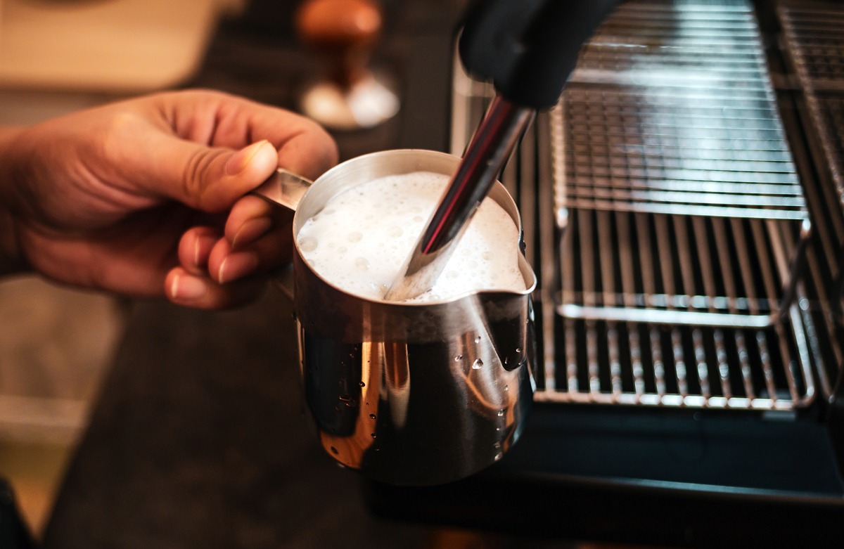 Napenenie mlieka v kanvičke pomocou parnej trysky v kávovare.